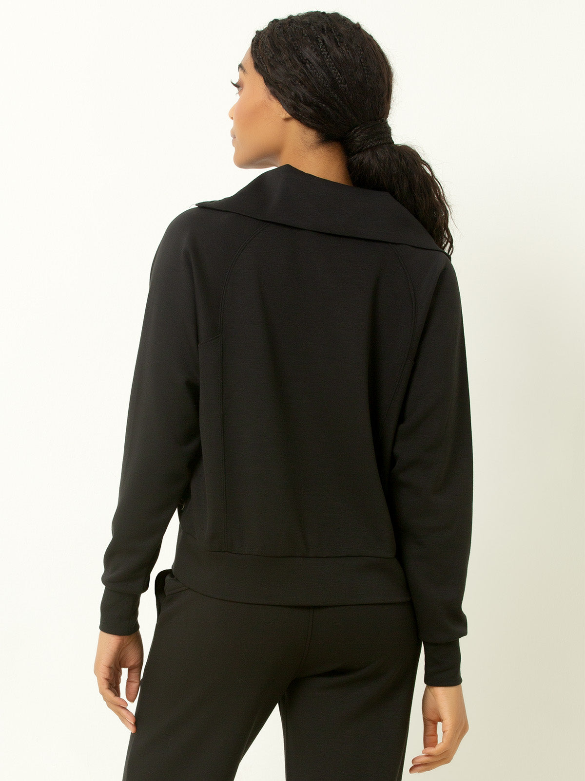 back shot of female model wearing black colored pullover sweatshirt.