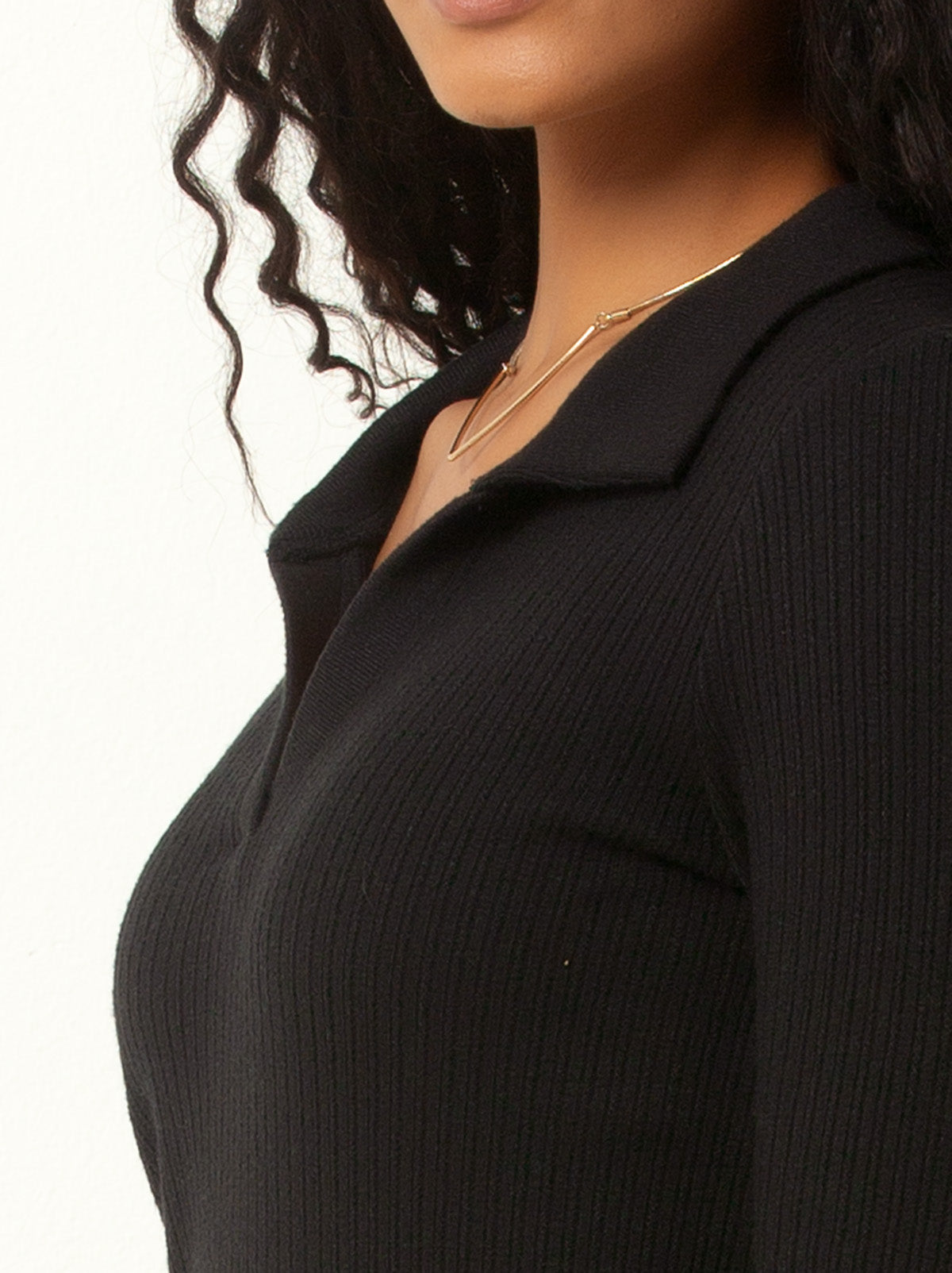 close up shot of female model waring a black colored v neck sweater with collar