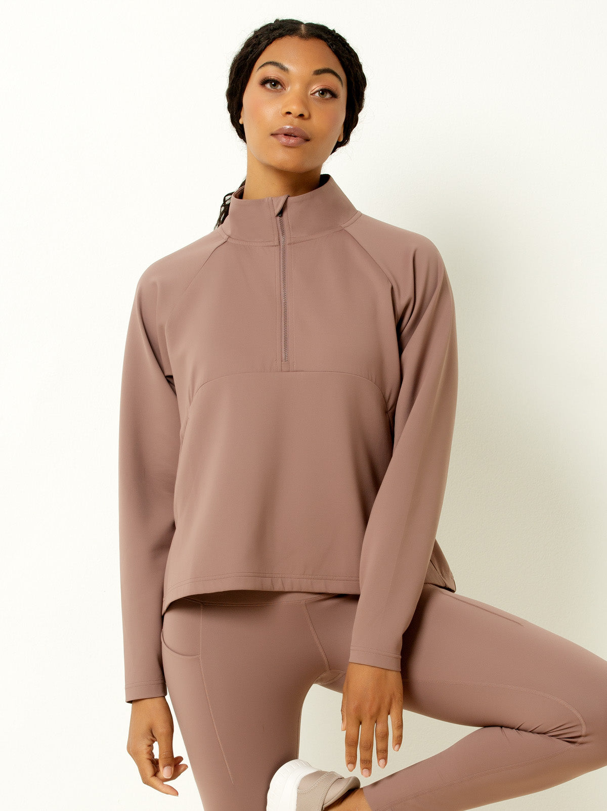 female model showing close up picture of mauve colored half zip pullover jacket