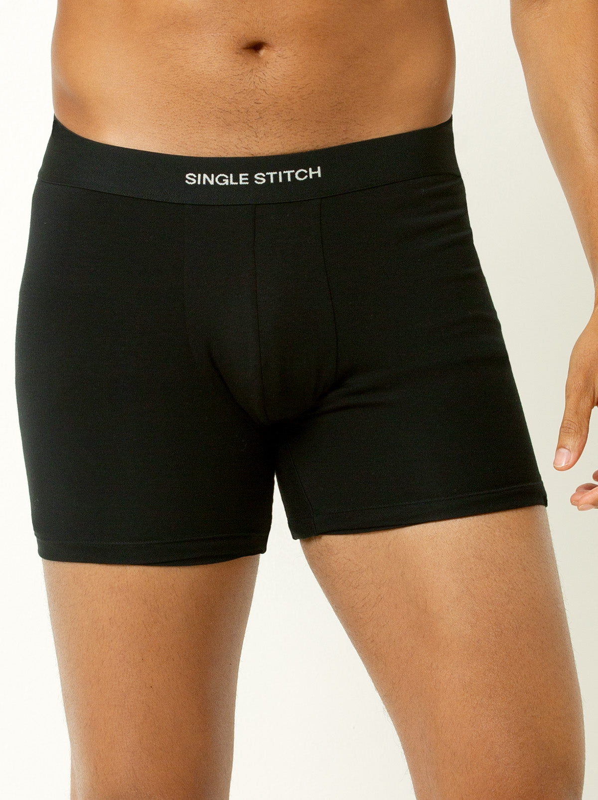 male model wearing black colored boxer briefs with single stitch logo on waist band