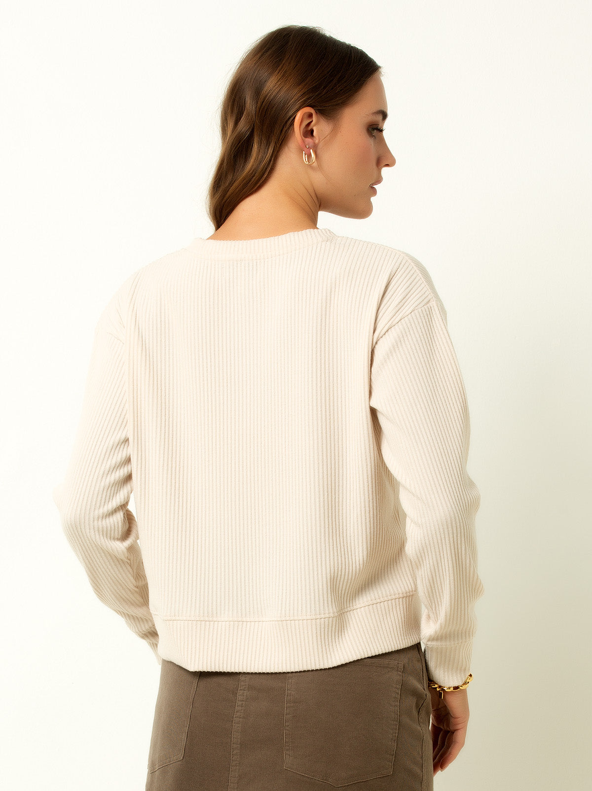 back shot of female model wearing a white colored ribbed cardigan sweater with buttons