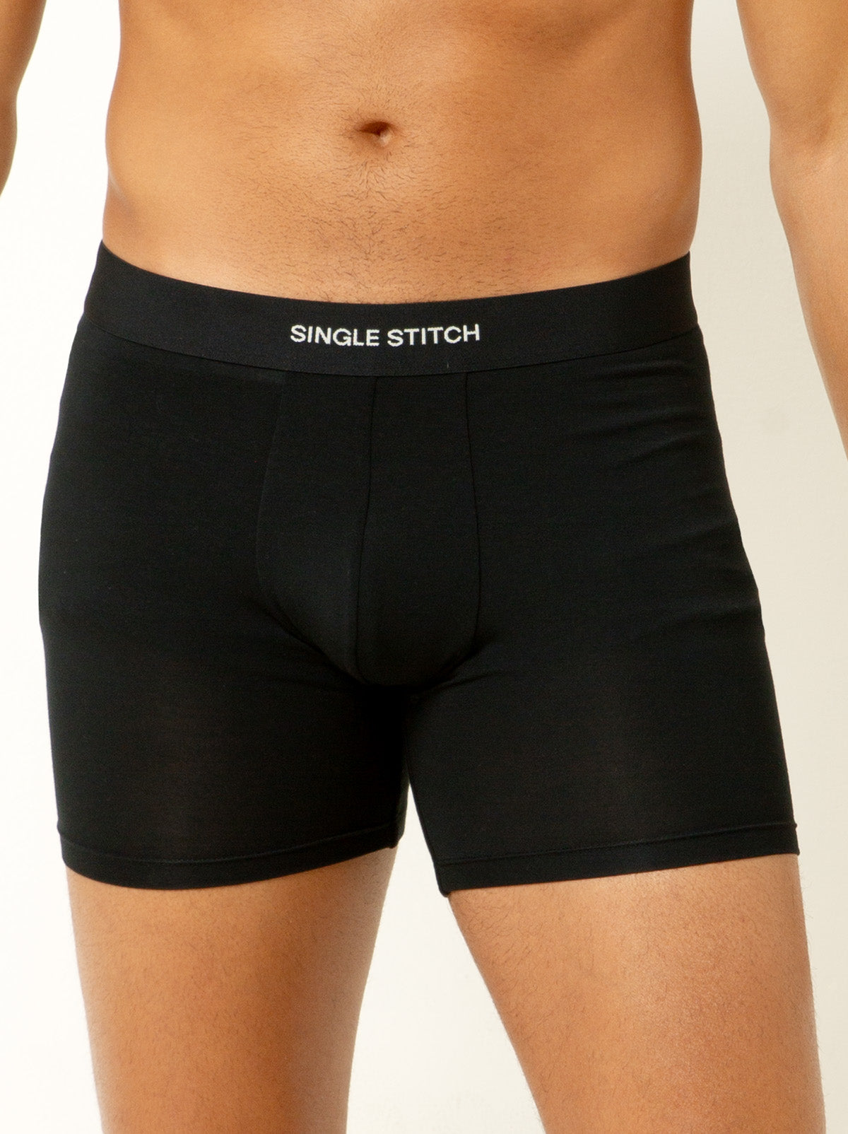 male model wearing black colored boxer briefs with single stitch logo on waist band