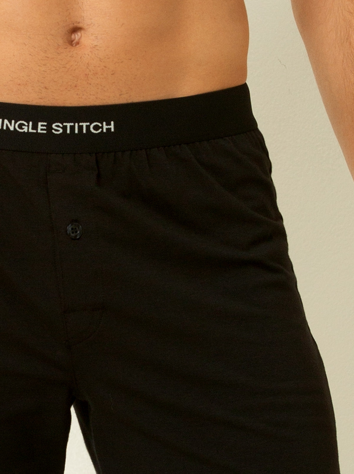 close up shot of male model wearing black colored briefs with single stitch logo on waist band