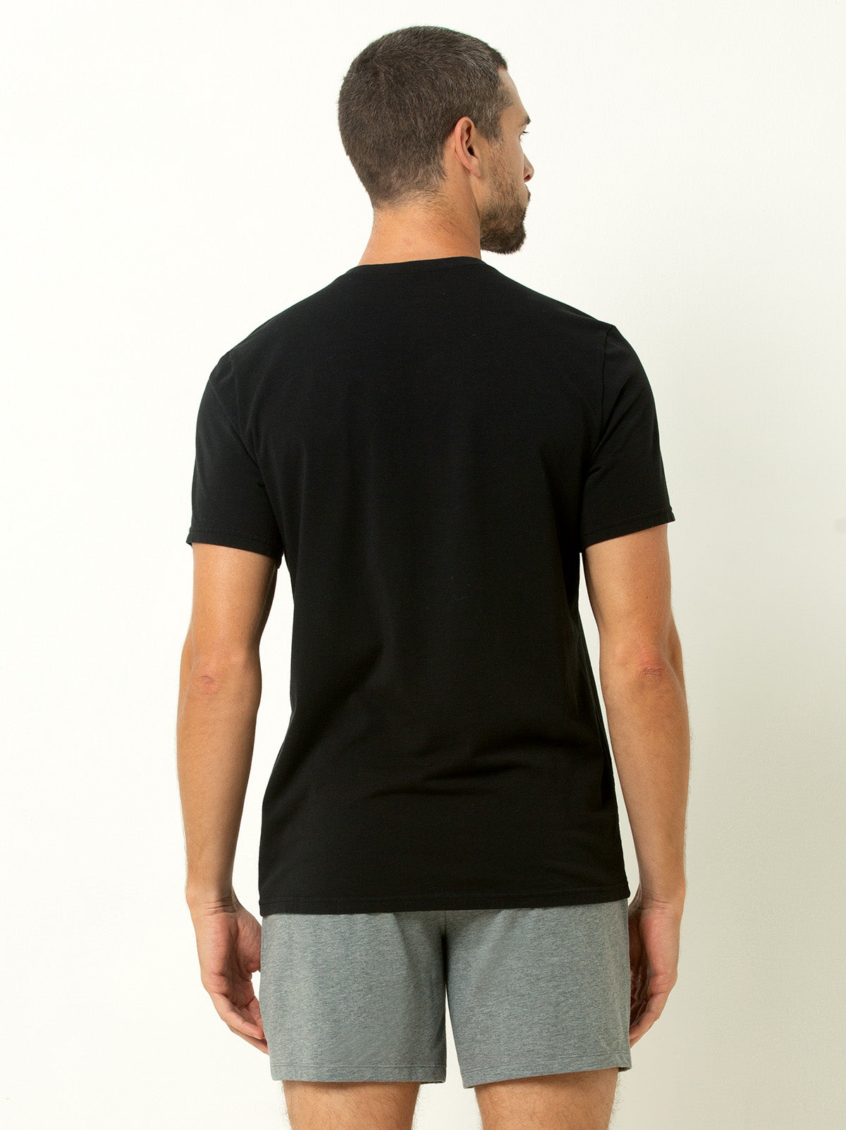 back shot of male model wearing black colored crew neck tee