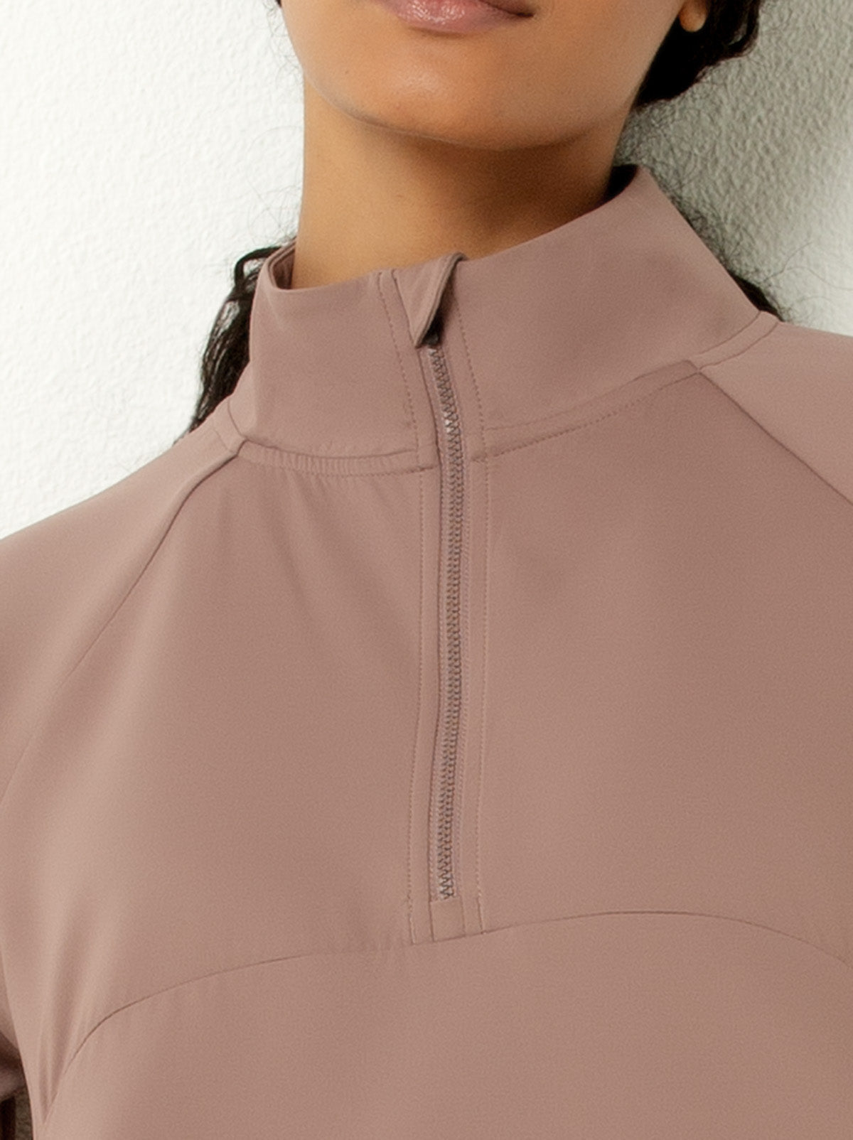 female model showing close up picture of mauve colored half-zip pullover jacket 
