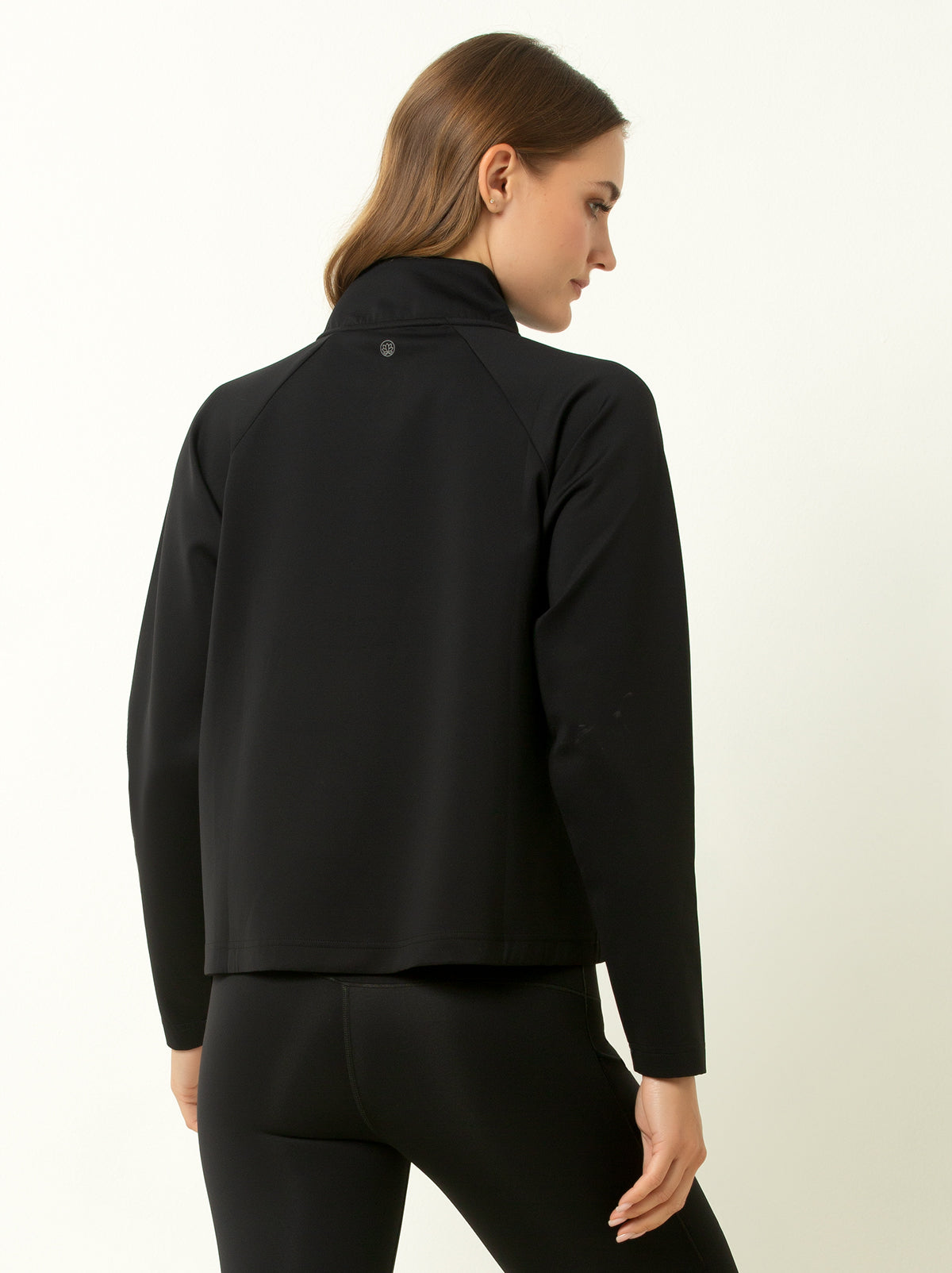 Female model showing back of black half-zip pullover.