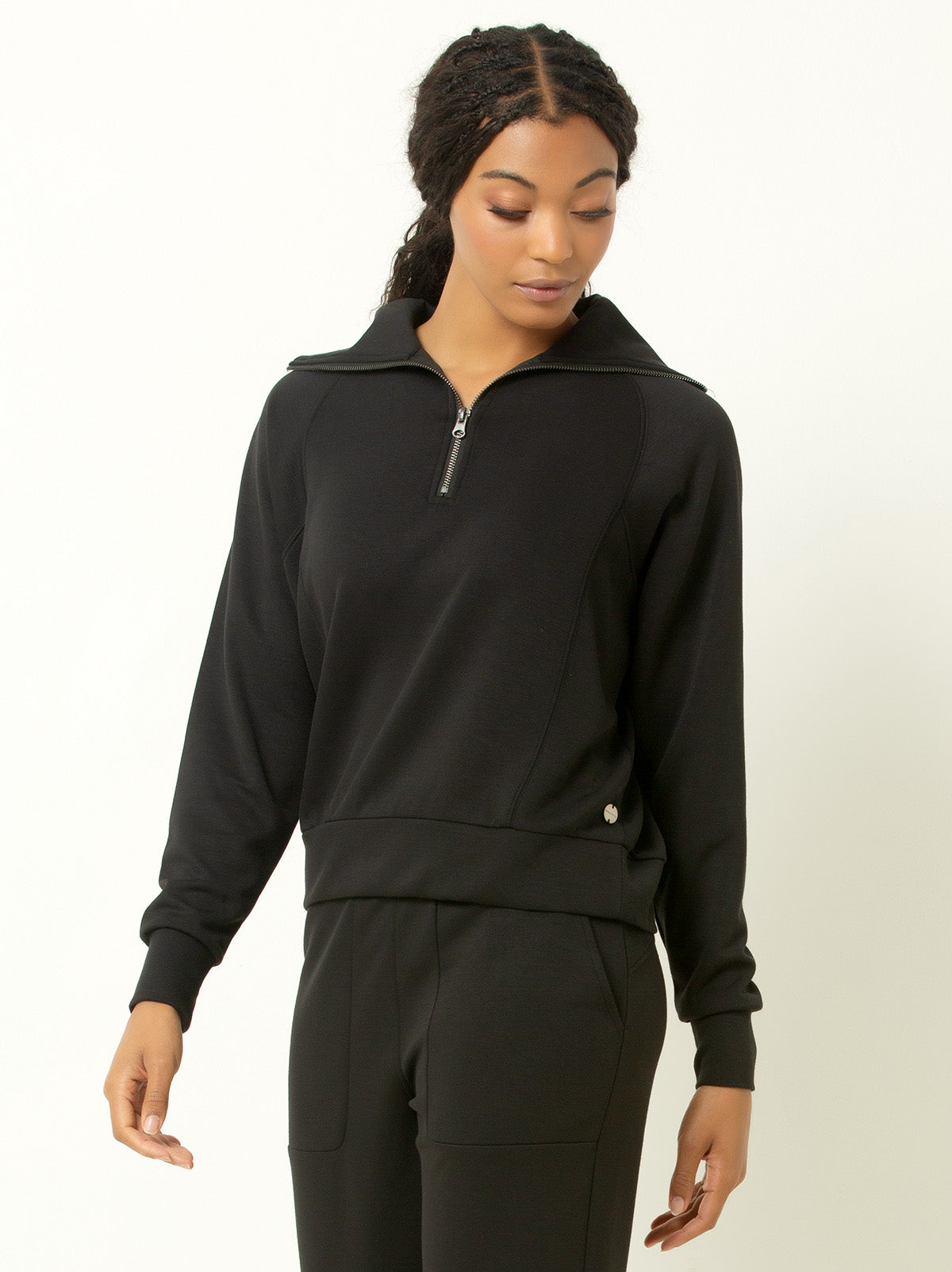female model wearing black colored quarter zip pullover sweatshirt.