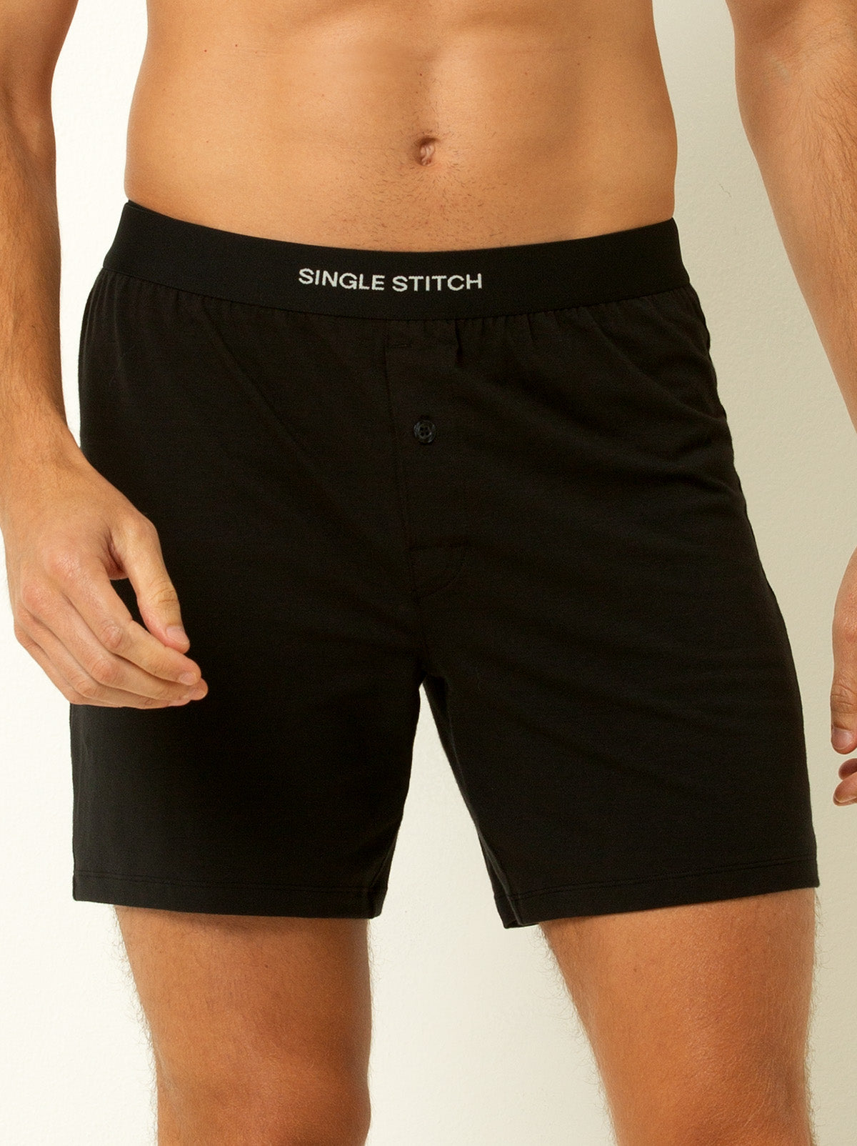 male model wearing black colored briefs with single stitch logo on waist band